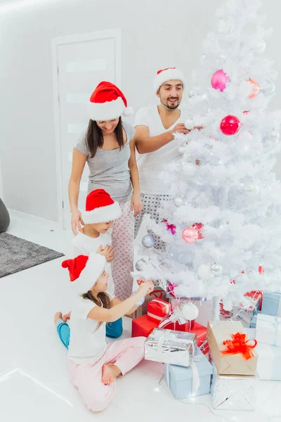 Familia decorando un árbol de Navidad con boubles en el salón — Foto de Stock
