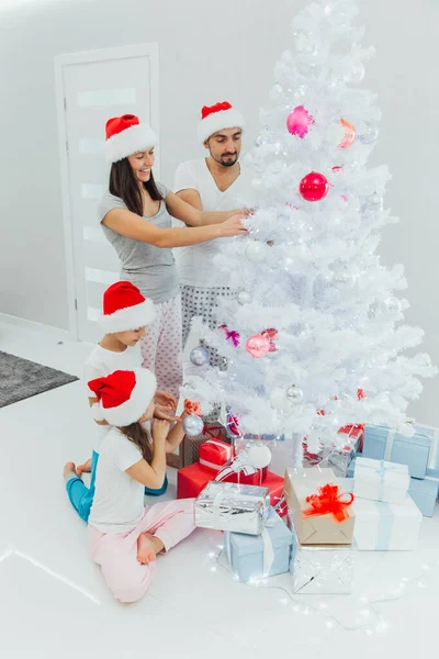 Різдвяна фотографія щасливої сім'ї навколо прикрашеної ялинки — стокове фото