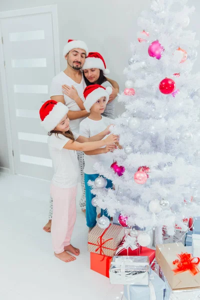 Χαμογελώντας οικογένεια διακοσμώντας ένα χριστουγεννιάτικο δέντρο στο σαλόνι και διασκεδάζοντας μαζί — Φωτογραφία Αρχείου