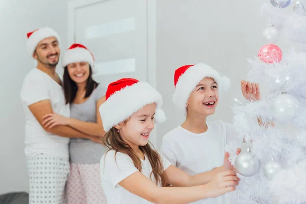 Діти прикрашають ялинку вдома. Різдвяний час — стокове фото