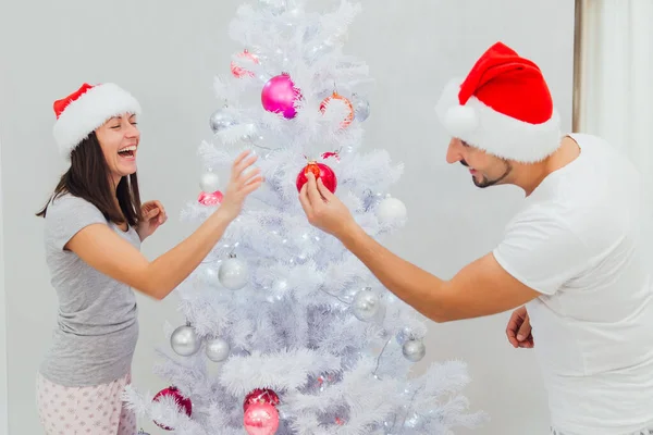 Χειμερινές διακοπές και οι άνθρωποι έννοια - ευτυχισμένο ζευγάρι διακόσμηση του Χριστουγεννιάτικου δέντρου στο σπίτι — Φωτογραφία Αρχείου