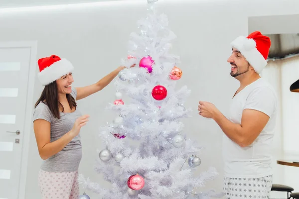 クリスマスの幸せなカップル新年の装飾された木家族の男と女白い背景の上に隔離された笑顔を愛する — ストック写真