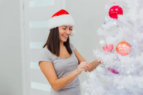 快乐的女人在家里装饰圣诞树。 微笑的女人庆祝圣诞节或新年。 圣诞树装饰。家庭 — 图库照片