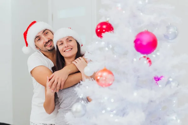 Ένα ζευγάρι που αγκαλιάζεται σε ένα χριστουγεννιάτικο δέντρο — Φωτογραφία Αρχείου