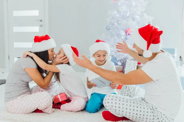 Jonge familie op kerstochtend cadeautjes uitwisselen en genieten van hun tijd samen — Stockfoto