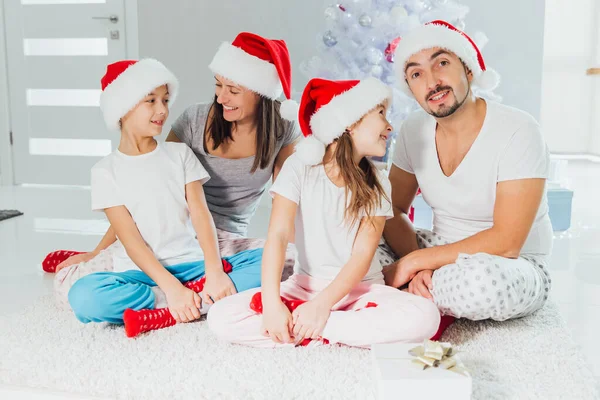 Padres e hijos felices intercambiando regalos cerca del árbol de Navidad en casa — Foto de Stock