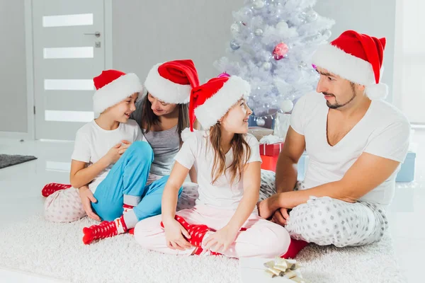 Pais felizes e crianças trocando presentes perto da árvore de Natal em casa — Fotografia de Stock