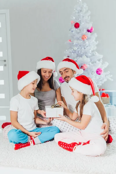 Padres e hijos felices cerca del árbol de Navidad en casa — Foto de Stock