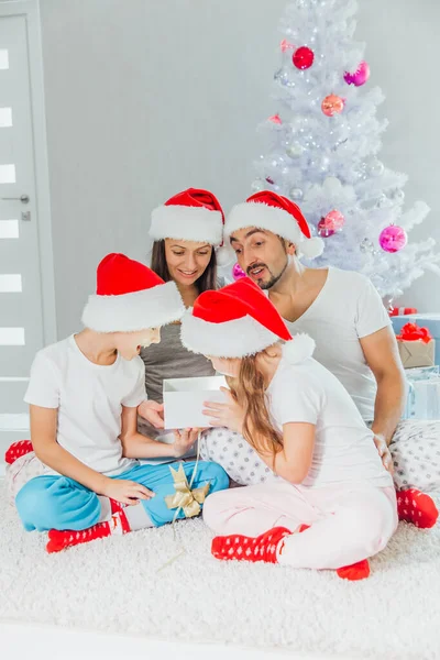 Feliz familia madre padre e hijos en la mañana de Navidad en pijamas regalos abiertos — Foto de Stock