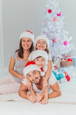 mutlu aile yalan yere şenlikli Noel ağacı, Noel hediyeleri yakınındaki oteller