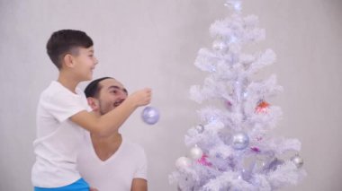 Küçük oğlu ağacın en üst dalına pembe bir mücevher asmak istiyor. Babası onu alıyor, çocuk istediğini yapıyor ve sonuçtan tatmin olmuş beş hareket yapıyorlar..