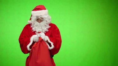 Noel Baba hediyelerle çantaya bakar ve kafasına dokunur. krom anahtarı