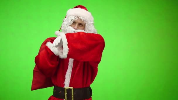 Chroma key. tired Santa Claus in white gloves carries a red bag with gifts over his shoulder — Stock Video