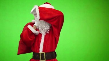 Chroma anahtar. Beyaz eldiven yorgun Noel Baba'ya hediyeler ile kırmızı bir çanta omzunun üzerinden taşır.