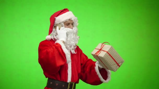 Santa Claus talking by phone and holding gift box. Christmas holiday concept. chromakey — Stock Video