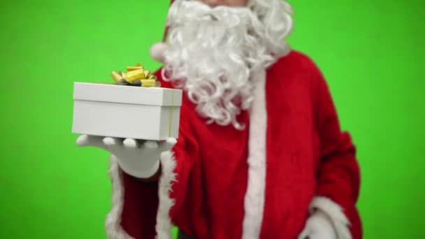 Papai Noel luva mãos segurando caixa de presente. fundo verde. de perto — Vídeo de Stock