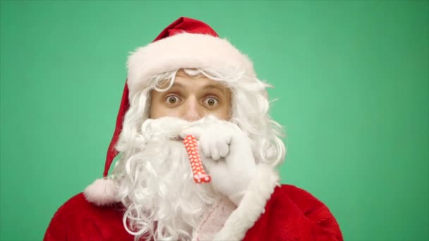 Санта-Клаус с праздничным свистом готов к празднованию Рождества. Санта Клаус празднует зимние праздники. Хрома-ключ. Закрывай. Медленное движение — стоковое видео