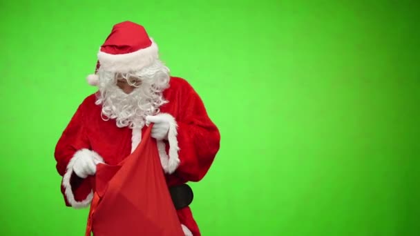 Santa gets a gift from a bag on green background — Stock Video