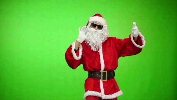 Санта Клаус в солнечных очках танцует и смотрит в камеру, хроматический ключ. замедленное движение — стоковое видео