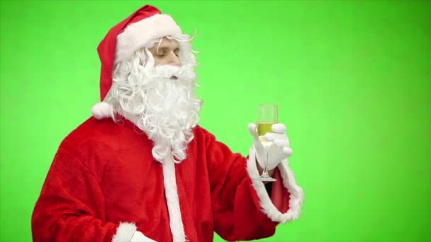 Santa Claus slaví Vánoce se sklenkou šampaňského izolovanou na zelené. zpomalený pohyb — Stock video