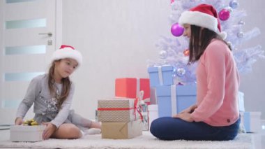 Anne ve kızı tüm aile üyelerine hediyeler paketledi ve onlardan bir yığın yaptı..