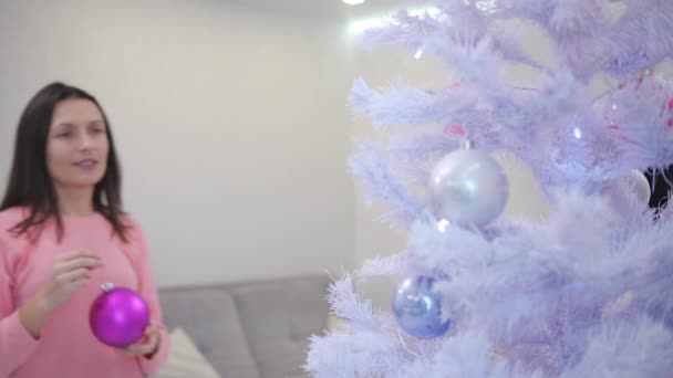 Güzel genç bayan Noel ağacı süslemekten memnun, tatil ruhunun keyfini çıkarıyor.. — Stok video