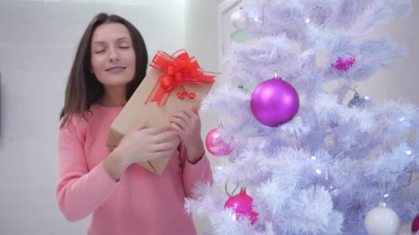 Mamá feliz, encontró un regalo para sí misma bajo el árbol de Navidad y le gusta tanto, sintiéndose agradecida . — Vídeo de stock