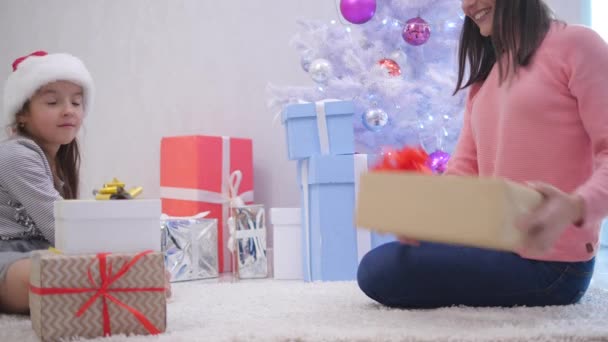 Mama en dochter pakten cadeautjes voor alle familieleden en maakten er een stapel van.. — Stockvideo
