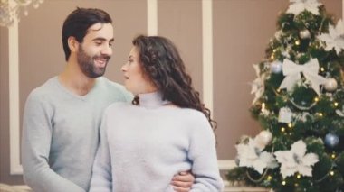 Genç mutlu çift Noel arifesinde Noel şarkıları söylüyor.