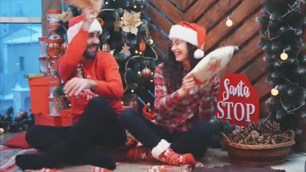 Full-body video of lively adults having fun, playing pillows fight on Christmas Eve. — Stock Video