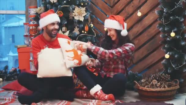 Full-body video of lively adults having fun, playing pillows fight on Christmas Eve. — Stock Video