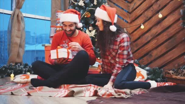 Video fHD of affectionate girl giving Christmas present to her boyfriend but she doesnt get anything in return. — Stock Video