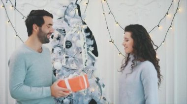 Yavaş çekim videosunda oğlan kız arkadaşına hediye kutusu veriyor, kız almak istiyor, ama oyuncu çocuk elinden kaçırmıyor..
