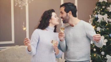 Havalı adam ve kadının ellerinde şampanya kadehleri ve Bengal lambalarıyla dilek tuttukları bir video..