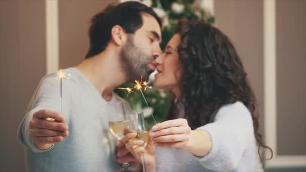 Close-up de casal amoroso na atmosfera de férias, de pé com luzes de bengala e champange, beijando . — Vídeo de Stock