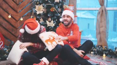 Canlı yetişkinlerin Noel arifesinde yastık savaşı yapıp eğlendiği ağır çekim videosu..