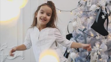 Komik at kuyruklu küçük çocuk Noel ağacının yanında duruyor, baş parmağını kaldırıyor çünkü onun ağacı en iyisi..