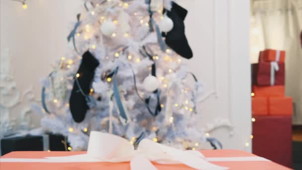Primer plano de vídeo de la joven súper emocionada abriendo gran regalo de Navidad mientras está sentado en el piso de la sala de estar . — Vídeos de Stock