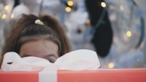 Vídeo recortado de la niña súper emocionada con la intención de abrir su regalo de Navidad . — Vídeo de stock