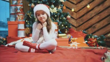 Noel Baba Noel ağacının yanında oturan çocuk, kendi tarafındaki metin ya da ürün için boşluğu işaret ediyor..