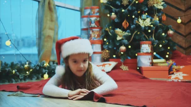 Une fille dort sous le sapin et se réveille soudainement, regardant tout autour, effrayée, mais s'assure alors que tout va bien et s'endort à nouveau . — Video