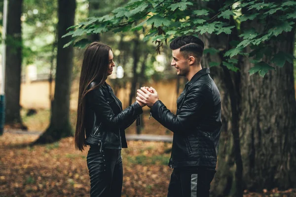 Νεαρό ζευγάρι στο πάρκο δασικής φύσης στα τέλη του φθινοπώρου. Ο άντρας ζεσταίνει τα χέρια των κοριτσιών.. — Φωτογραφία Αρχείου