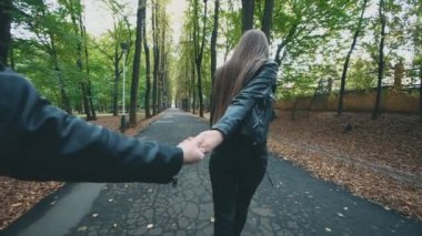 Güz parkında genç ve mutlu bir kadın gülümsüyor. Tamamen siyah görünüş. Ağır çekim. Uzayı kopyala 4K.