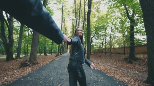 Joven mujer bastante feliz está sonriendo en el parque de otoño. Mirada negra total. En cámara lenta. Copiar espacio. 4K . — Vídeo de stock