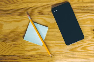 Siyah modern martphone ve üzerinde kalem olan bir kağıt..