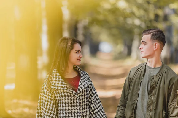 Igaz szerelem. Gyönyörű fiatal pár fogja egymás kezét és szemkontaktust tart a napsütéses őszi napon a parkban. — Stock Fotó