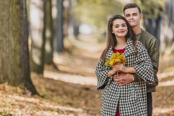 Romantisches Paar entspannt im Herbstpark, kuschelt, genießt frische Luft und schönes Herbstwetter. — Stockfoto