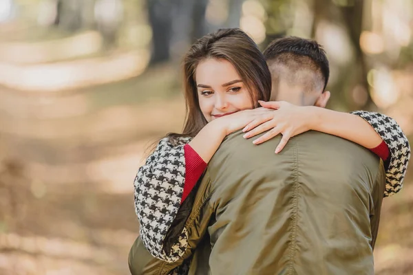 Euphoric young couple meeting and hugging in autumn park after long time on distance. — Stock Photo, Image