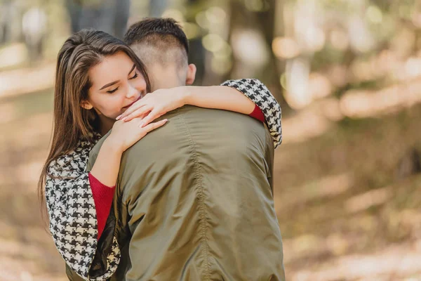 Euphoric young couple meeting and hugging in autumn park after long time on distance. — Stock Photo, Image