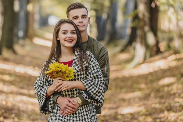 Romantisches Paar entspannt im Herbstpark, kuschelt, genießt frische Luft und schönes Herbstwetter. — Stockfoto